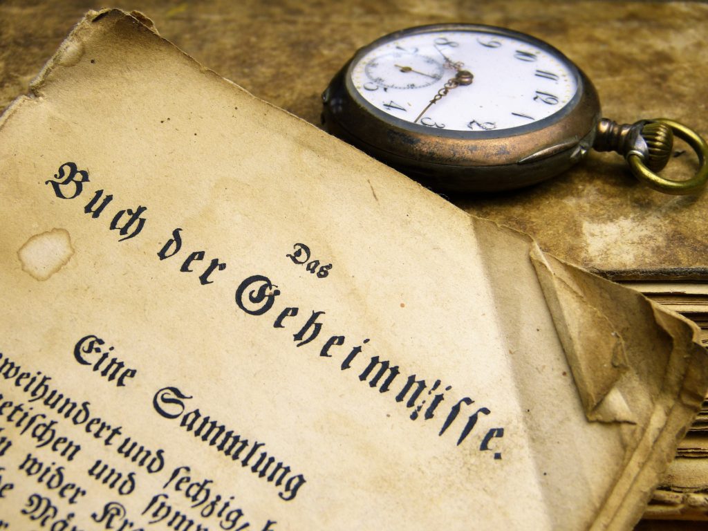 Altes Buch mit altdeutscher Schrift und eine Alte Taschenuhr