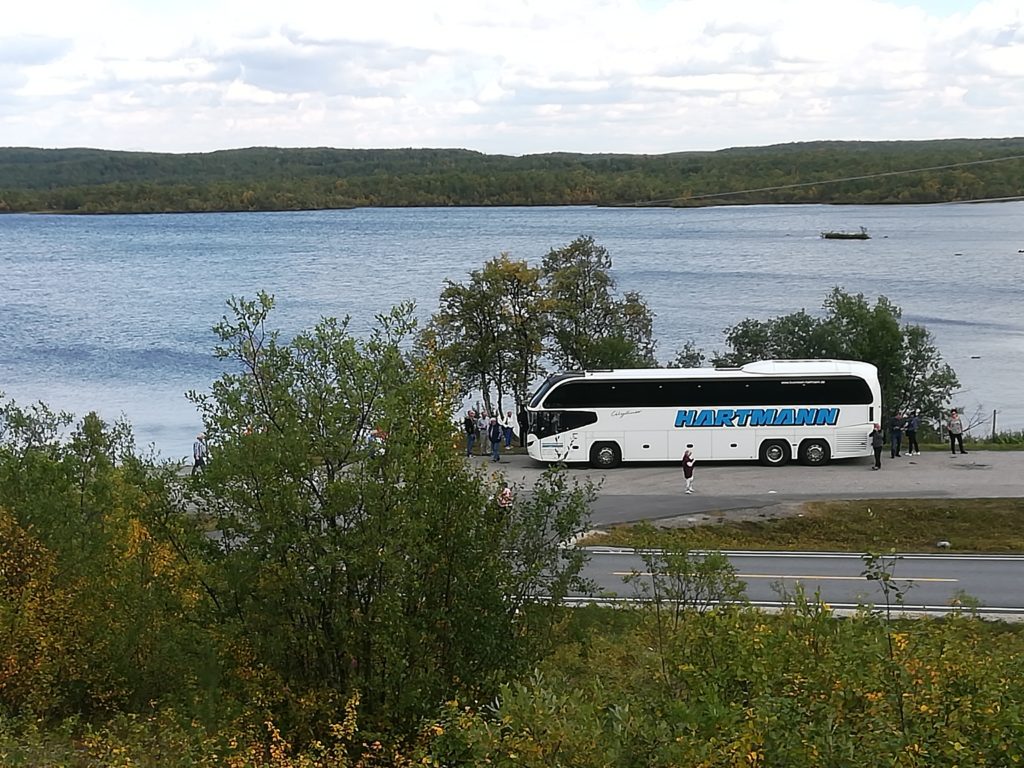 Busreise Gruppenreise weißer Reisebus mit getönten Scheiben im Hintergrund ein See Norwegen