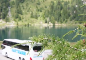 Busreise Reisebus Busreise weißer Reisebus mit getönten Scheiben am See