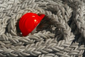 Helm im Schiffstau Roter Arbeitshelm im Schiffstau
