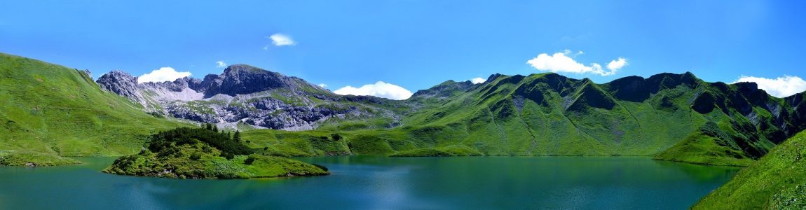 Busreise Deutschland Alpen Blick auf Stausee und grüne Berglandschaft